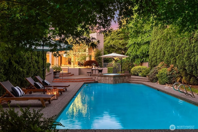 pool at dusk featuring an outdoor pool and a patio area