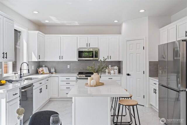 28648 226th Ave SE, Maple Valley, WA 98038 - kitchen featuring stainless steel appliances, light marble finish flooring, a sink, a kitchen island, and recessed lighting