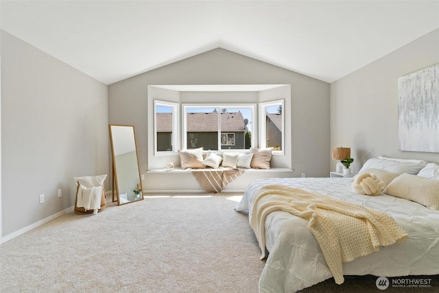 carpeted bedroom with vaulted ceiling and baseboards