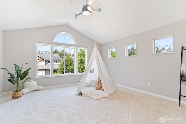 recreation room featuring carpet flooring, a ceiling fan, baseboards, and lofted ceiling
