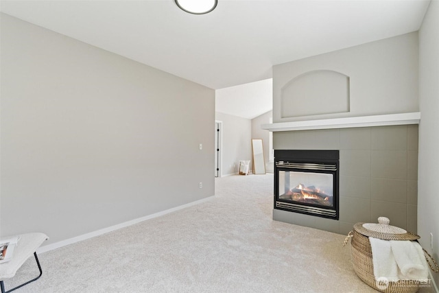 carpeted living room featuring a multi sided fireplace and baseboards