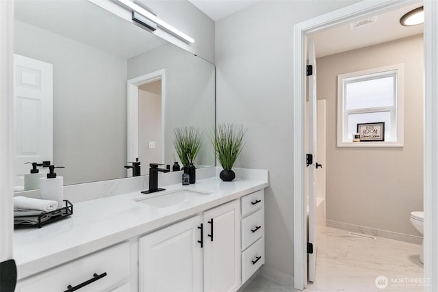 bathroom featuring vanity, baseboards, toilet, and marble finish floors