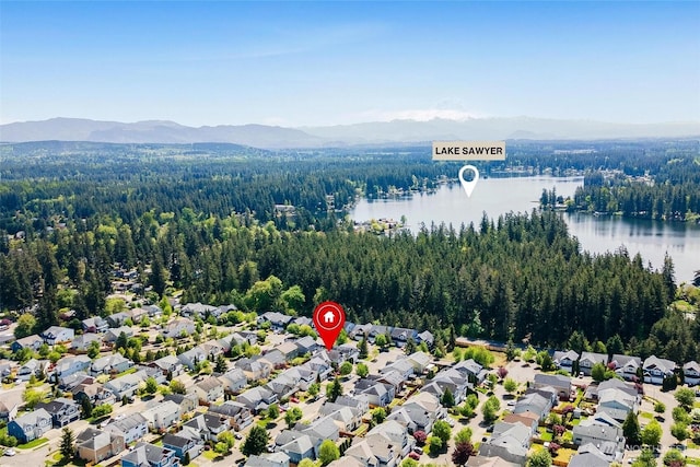 aerial perspective of suburban area featuring a forest and a water and mountain view