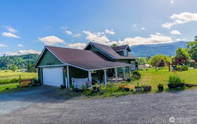 121 Temple Rd, Morton, WA 98356 - view of property exterior with a detached garage, a mountain view, a porch, and a lawn