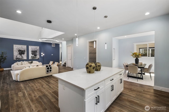 kitchen with dark wood-style flooring, white cabinetry, decorative light fixtures, open floor plan, and a center island