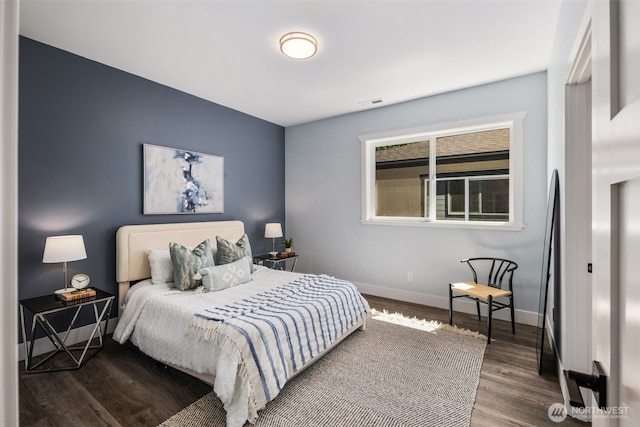 bedroom with baseboards and wood finished floors