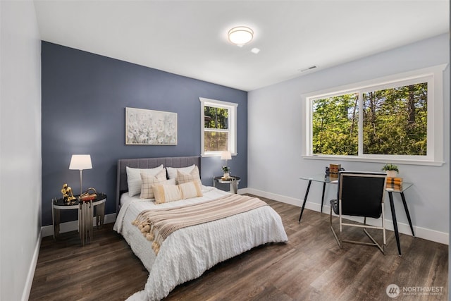 bedroom with wood finished floors and baseboards