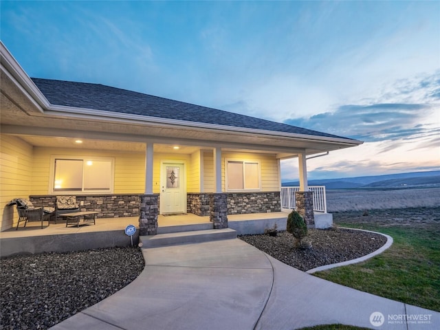 23201 Rd 12 NW, Quincy, WA 98848 - property entrance with stone siding, a porch, outdoor lounge area, and a shingled roof