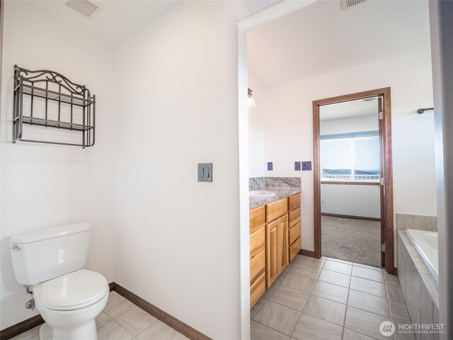 23201 Rd 12 NW, Quincy, WA 98848 - bathroom with vanity, toilet, baseboards, tiled bath, and tile patterned flooring
