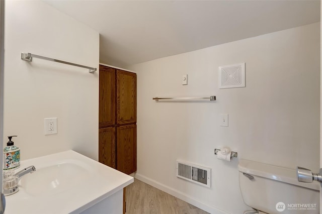 130 Priest Point Dr NE, Tulalip, WA 98271 - bathroom featuring wood finished floors, toilet, baseboards, and a sink