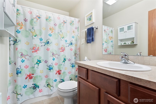 bathroom with toilet, vanity, backsplash, and tile patterned flooring