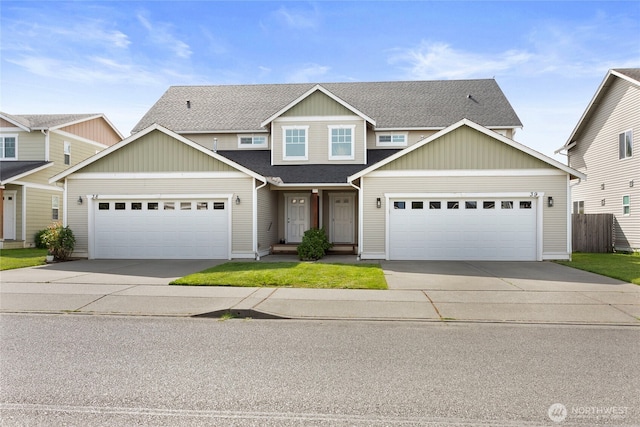 view of front facade with driveway, an attached garage, roof with shingles, and fence