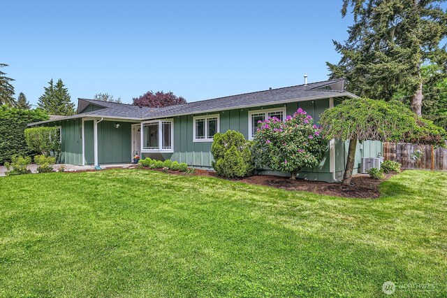 single story home with board and batten siding, a front lawn, and roof with shingles
