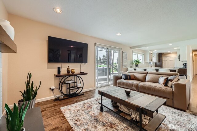 living area featuring baseboards, recessed lighting, and wood finished floors