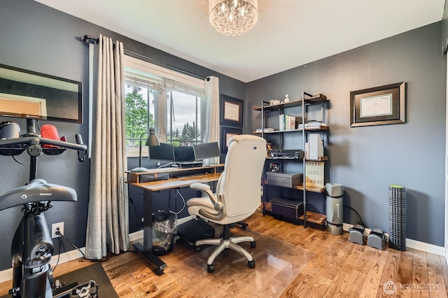 office with wood finished floors, baseboards, a chandelier, and a textured wall