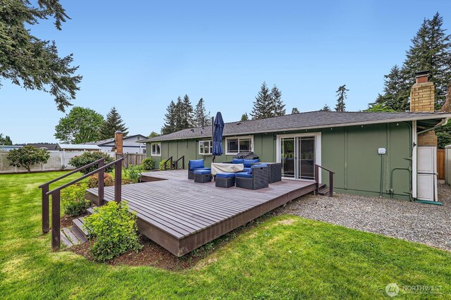 rear view of property with a chimney, an outdoor living space, and a deck