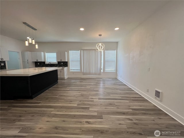 2802 Sumner Ave, Hoquiam, WA 98550 - kitchen with wood finished floors, a sink, a notable chandelier, white cabinets, and light countertops