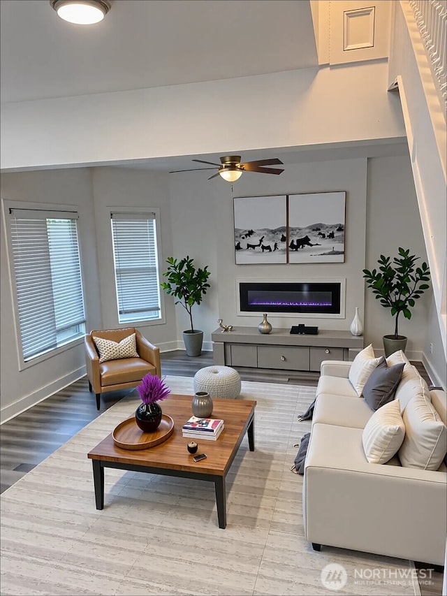 2802 Sumner Ave, Hoquiam, WA 98550 - living room featuring light wood-type flooring, baseboards, a ceiling fan, and a glass covered fireplace