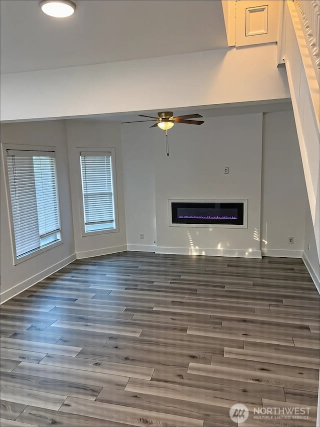 2802 Sumner Ave, Hoquiam, WA 98550 - unfurnished living room with a ceiling fan, baseboards, a glass covered fireplace, and wood finished floors