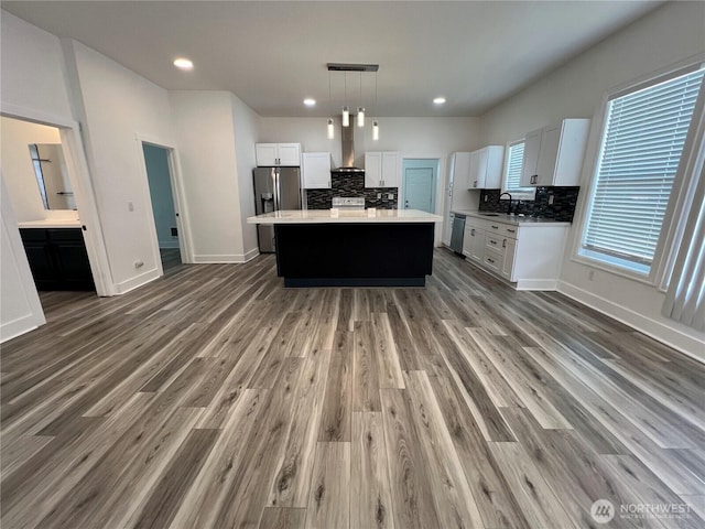 2802 Sumner Ave, Hoquiam, WA 98550 - kitchen with stainless steel appliances, white cabinetry, wall chimney range hood, and backsplash