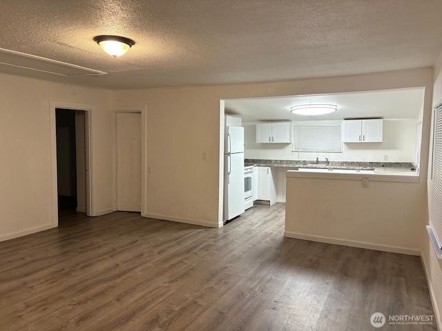 2802 Sumner Ave, Hoquiam, WA 98550 - unfurnished living room featuring a textured ceiling, a sink, and dark wood-style floors