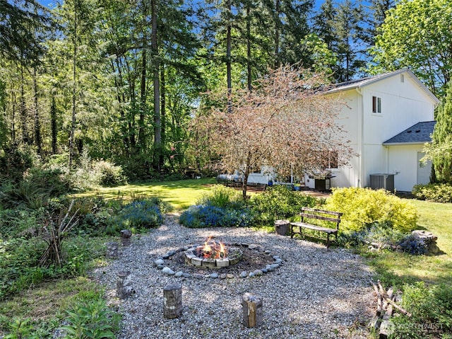 view of yard with an outdoor fire pit and central air condition unit
