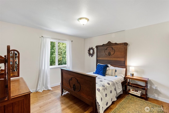bedroom with light wood-style flooring and baseboards