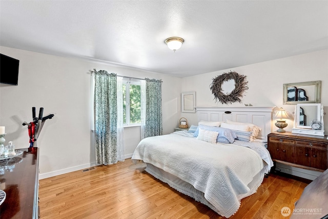 bedroom with light wood-type flooring and baseboards