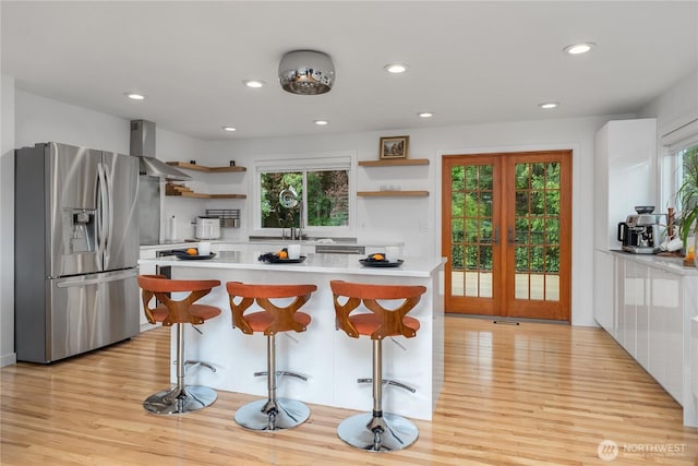 18810 111th Pl SE, Renton, WA 98055 - kitchen with stainless steel fridge with ice dispenser, open shelves, wall chimney range hood, light wood-style floors, and recessed lighting