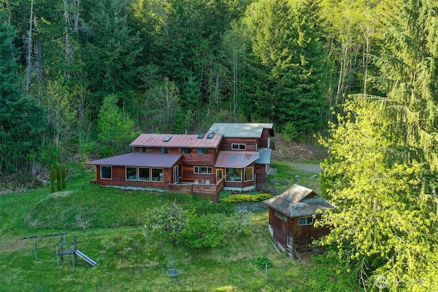 aerial view of property and surrounding area with a heavily wooded area