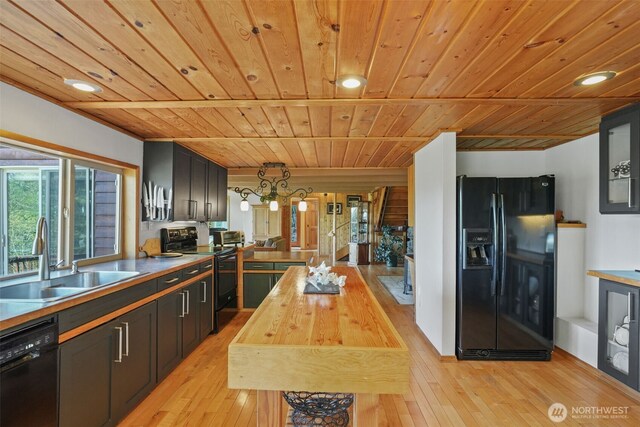 kitchen featuring black appliances, a sink, wood ceiling, butcher block counters, and light wood-type flooring