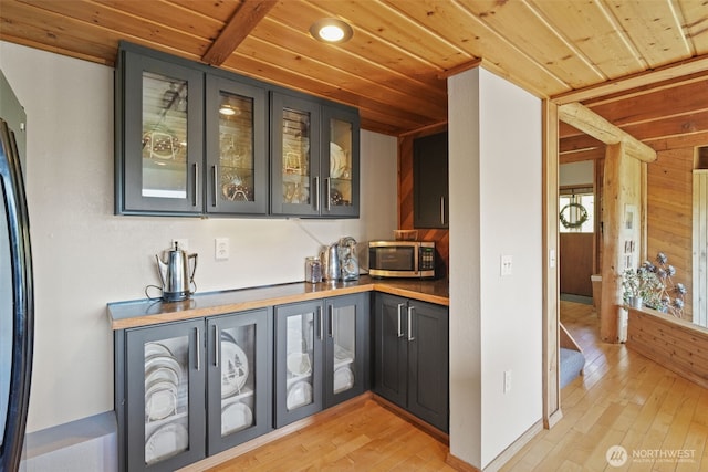 bar area featuring stainless steel microwave, wood ceiling, light wood-style flooring, freestanding refrigerator, and recessed lighting