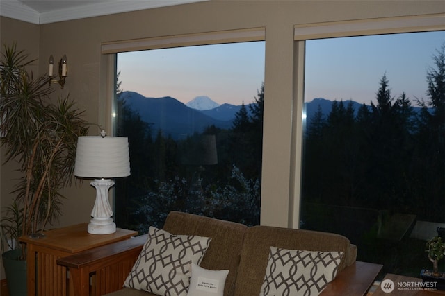 living area featuring a mountain view and crown molding