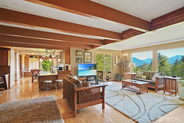 living room featuring light wood-style flooring, a chandelier, and beam ceiling