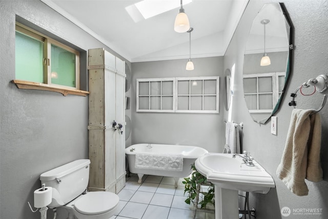 full bathroom featuring vaulted ceiling, tile patterned flooring, a freestanding tub, toilet, and a skylight