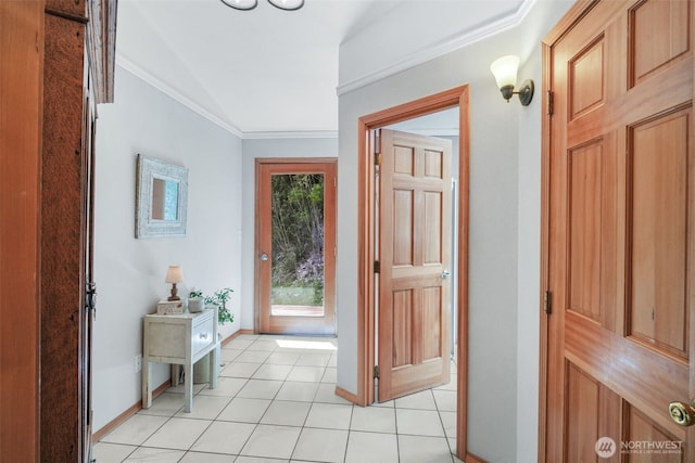 foyer with light tile patterned flooring, vaulted ceiling, ornamental molding, and baseboards