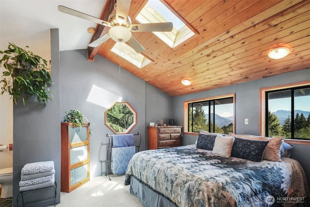 bedroom with a skylight, light carpet, lofted ceiling, wood ceiling, and a ceiling fan