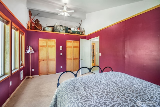 carpeted bedroom featuring multiple closets, high vaulted ceiling, and baseboards