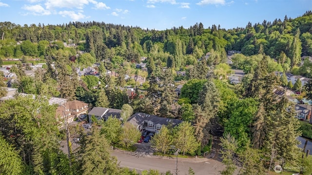 aerial view of property's location with a forest and nearby suburban area