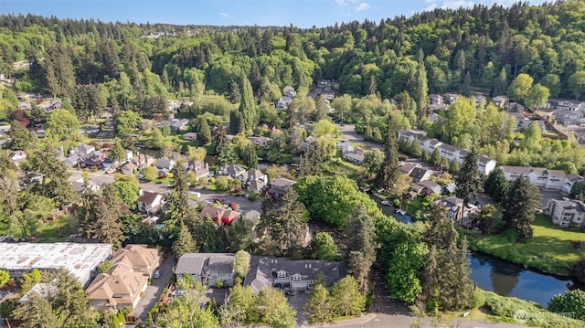 view of property location featuring nearby suburban area and a heavily wooded area