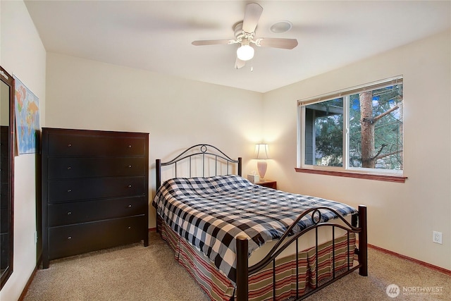 bedroom featuring light colored carpet, baseboards, and ceiling fan