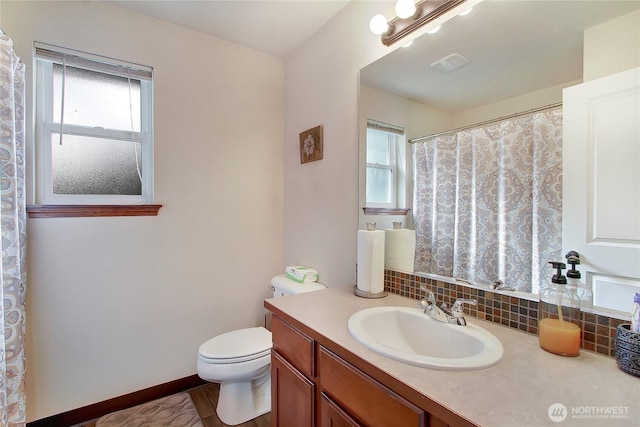 full bathroom with healthy amount of natural light, toilet, vanity, and curtained shower
