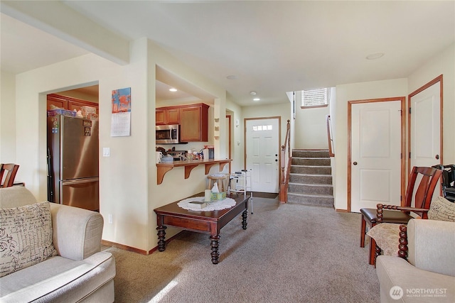 carpeted living area featuring baseboards, recessed lighting, and stairs