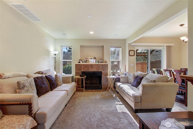living room with a tiled fireplace and recessed lighting