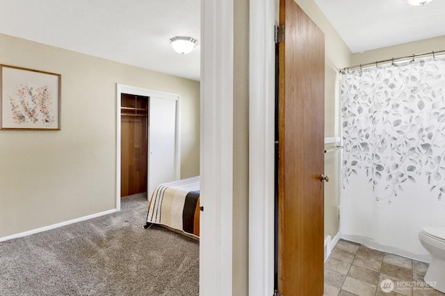 unfurnished bedroom with light colored carpet, a closet, and baseboards