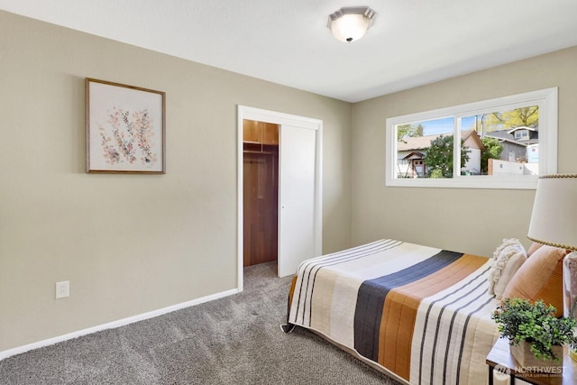 carpeted bedroom with a closet and baseboards