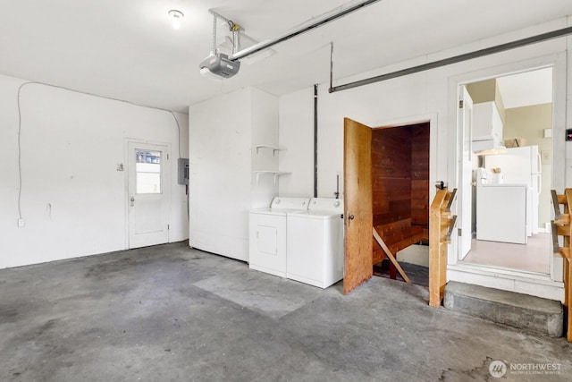 garage featuring freestanding refrigerator, washing machine and dryer, and a garage door opener