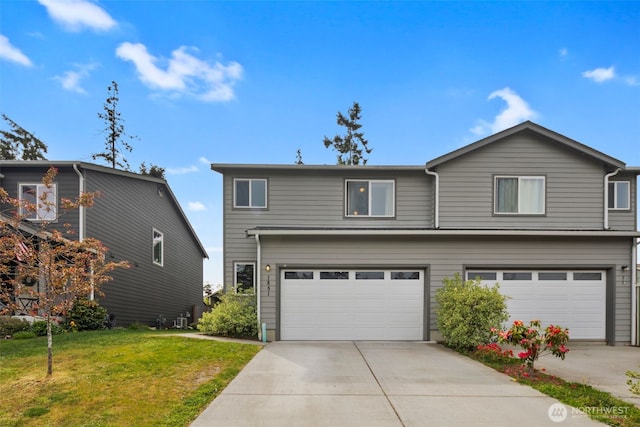 view of front of home with a garage, a front yard, and driveway