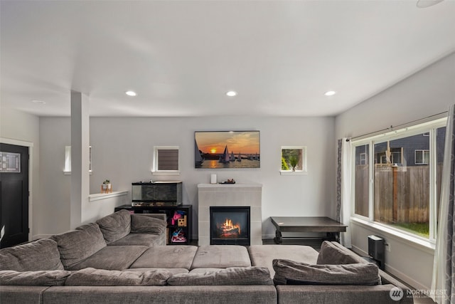 living area with recessed lighting and a tile fireplace
