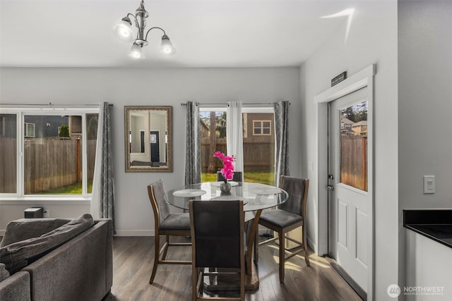 dining area with wood finished floors, baseboards, and a chandelier